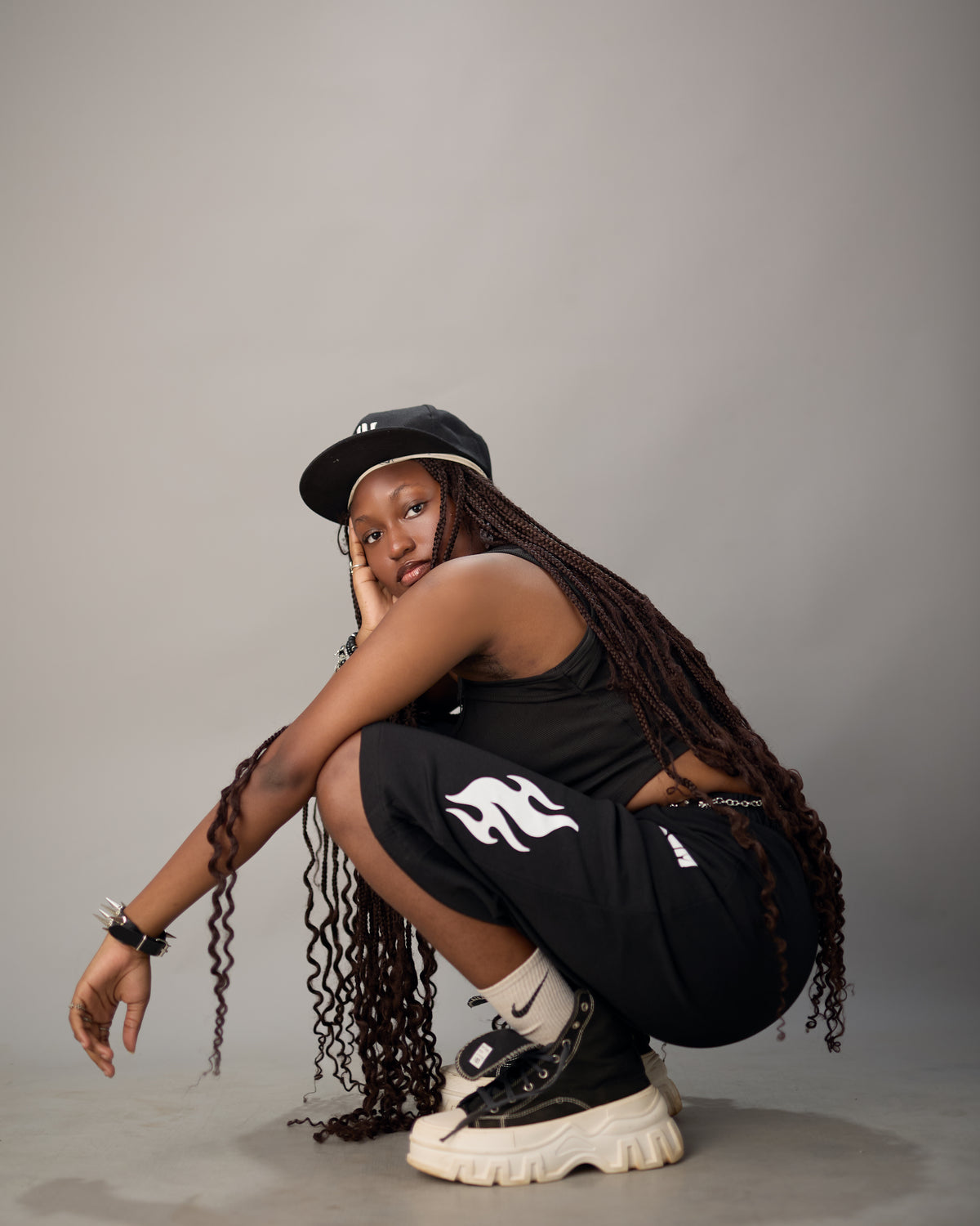 Model in Aurum Styles streetwear: black cap, tank top and graphic joggers